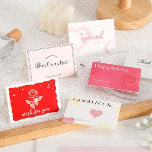 Gros plan de cartes de vœux minimalistes avec texte Best Wishes sur un bureau blanc