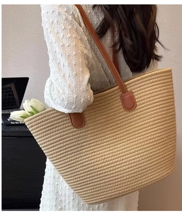 Detailed shot of large woven cotton tote bag with leather handles and tight horizontal weave