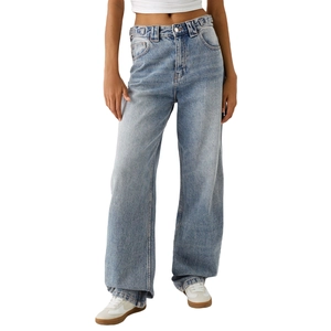 Gros plan d'un jean large en denim bleu délavé montrant la taille haute et le tissu