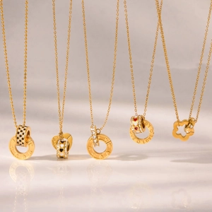 Primer plano de collares dorados con colgantes de diamantes y grabado de LOVE