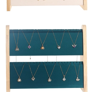 Detail of dark green velvet necklace stand with wood frame and gold pendant displays