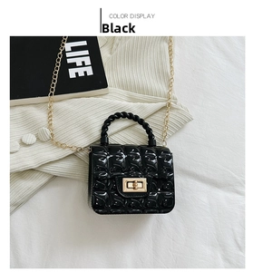 Close-up of black quilted jelly bag with gold twist lock and woven handle detail
