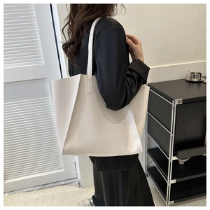 Detailed shoulder view of a minimalist white leather tote bag for daily commuting