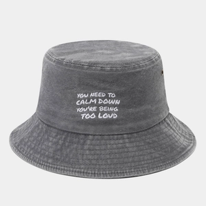 Detail of dark gray washed cotton bucket hat featuring embroidered text and metal eyelets