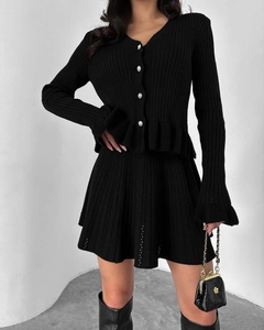 Détail d'un ensemble en maille noire style français avec boutons perlés et texture côtelée