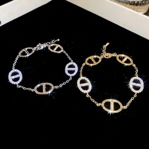 Gold and silver oval link bracelets with pavé zircons on black velvet background