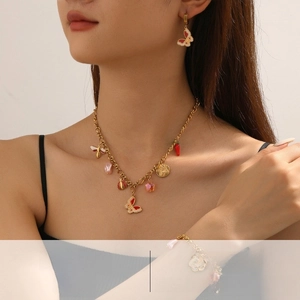 Detailed view of women's gold-plated jewelry set with butterfly and ladybug charms