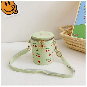 Close-up of light green cherry print bucket bag with flower-shaped golden zippers