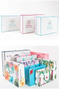 Close-up of artistic gift bags with tropical floral prints and braided rope handles