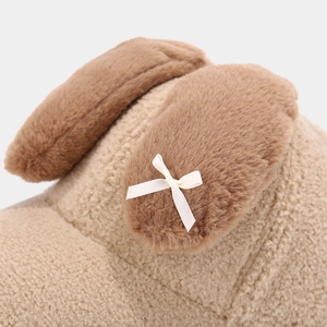 Détail d'oreilles de lapin en peluche avec nœud en soie sur une casquette d'hiver