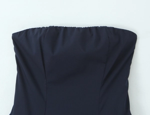 Dettaglio di un abito senza spalline blu scuro con texture fine e pieghe sul bordo superiore