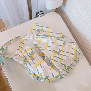 Detailed shot of floral cotton tote bag with soft yellow stripes and pink flower pattern