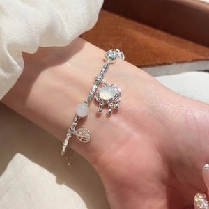 Silver beaded bracelet featuring a Fu charm and a cat-eye stone pendant on the wrist