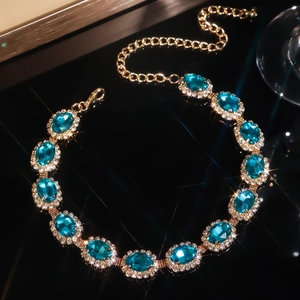 Multilayer gold necklace with oval lake blue crystals and sparkling rhinestone accents