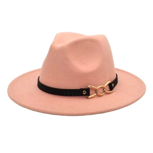 Dettaglio di cappello fedora in lana rosa con nastro nero e anelli dorati intrecciati