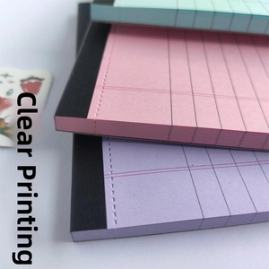 Close-up of colorful grid paper pads in pink, purple, and green with black glue binding