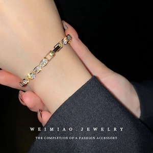 Elegant gold tennis bracelet with oval cubic zirconia stones worn on a female wrist