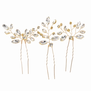 Detail of three-piece golden hairpins set with crystal rhinestones in leaf shapes