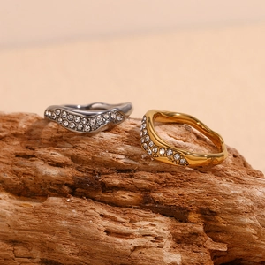 Detail of irregular wave rings in gold and silver plating with pavé white zircons