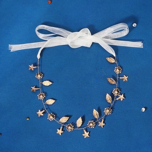 Elegant gold bridal hair vine with metallic stars, leaves, and a white ribbon tie