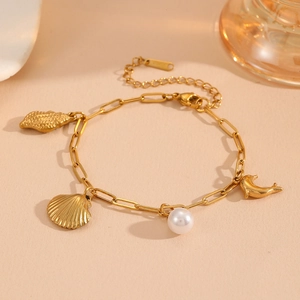 Detail of gold-plated stainless steel bracelet with shell, dolphin and pearl charms