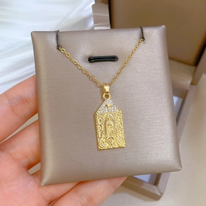 Close-up of golden Virgin Mary pendant with sparkling zircons on a luxury chain