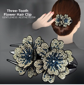 Détail d'une pince à cheveux à trois dents sertie de strass bleus et champagne brillants