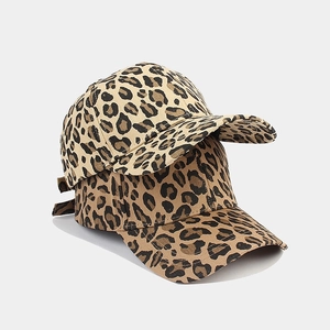 Close-up of stacked cow print baseball caps showing detailed fabric texture and patterns