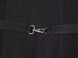Detail of silver metal buckle on black twill fabric with textured back strap adjustment