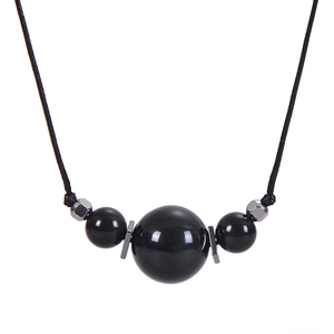 Detail of 16mm natural black stone pendant necklace with woven black cord strap
