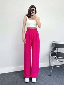 Détail du pantalon large taille haute rose fuchsia avec tissu texturé et bel effet drapé