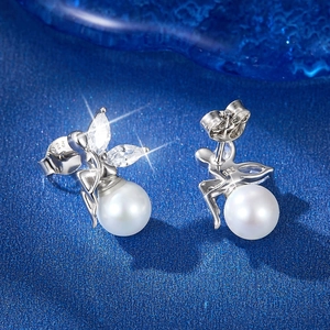 Macro shot of S925 silver fairy earrings with white pearl and zircon wings