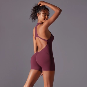 Detail of plum backless yoga bodysuit featuring cross-straps and peach lift shorts