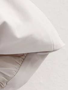 Close-up of off-white twill fabric texture and professional stitching on the flight jacket