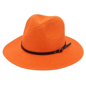 Dettaglio della trama del cappello di paglia Panama arancione con cinturino in pelle marrone