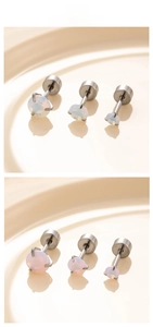 Detailed macro view of three sizes of opal titanium steel stud earrings on ceramic