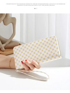 Close-up of a white leather long wallet featuring a yellow floral pattern and wrist strap