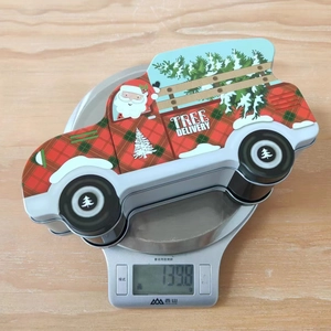 Detailed view of Christmas car-shaped tin box weighing 139.8g on digital scale
