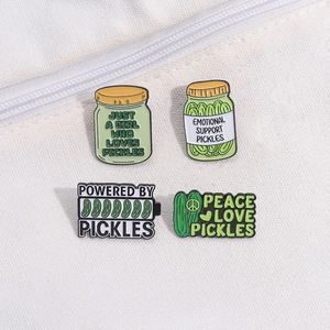 Set of four green pickle enamel pins with funny slogans on white canvas background