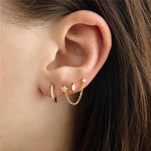 Macro view of gold plated S925 sterling silver earrings set with zircon stones on ear