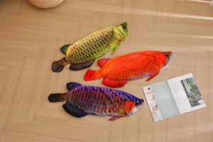 Detailed overhead view of three colorful plush dragon fish pillows on a wooden floor