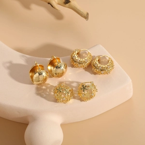 Detailed view of three pairs of 14K gold plated geometric hoop earrings with zircons