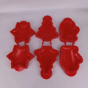 Detail view of red 3D Christmas tree, snowflake and mitten shaped cookie cutters