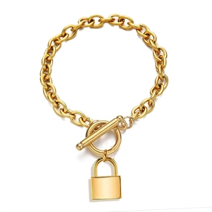 Detail shot of golden chunky chain link bracelet with OT toggle clasp and padlock pendant