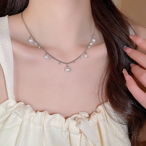 Close-up of elegant pearl tassel necklace with zircon charms on a delicate silver chain