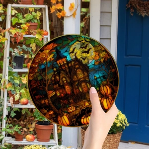 Detailed view of Halloween pumpkin house acrylic ornament held by hand on a porch