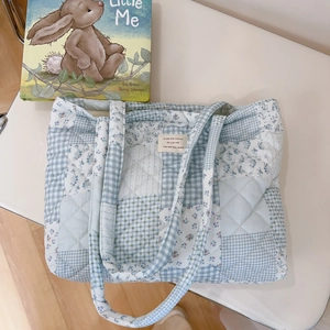Detailed close-up of blue floral patchwork quilted cotton tote with French label