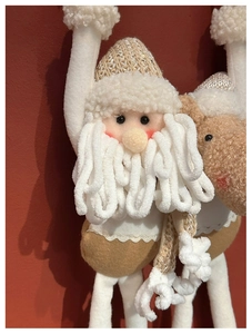 Detail of plush Santa and reindeer ornaments with knitted textures and soft fleece beard