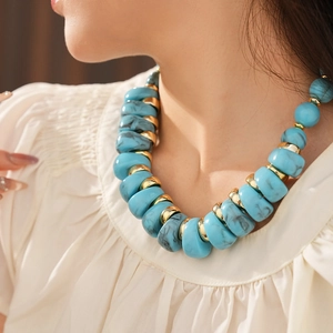 Gros plan d'un collier vintage avec perles turquoise bleues et intercalaires dorés