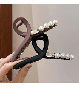 Détail de pinces à cheveux noir mat et brun moka avec des accents de perles